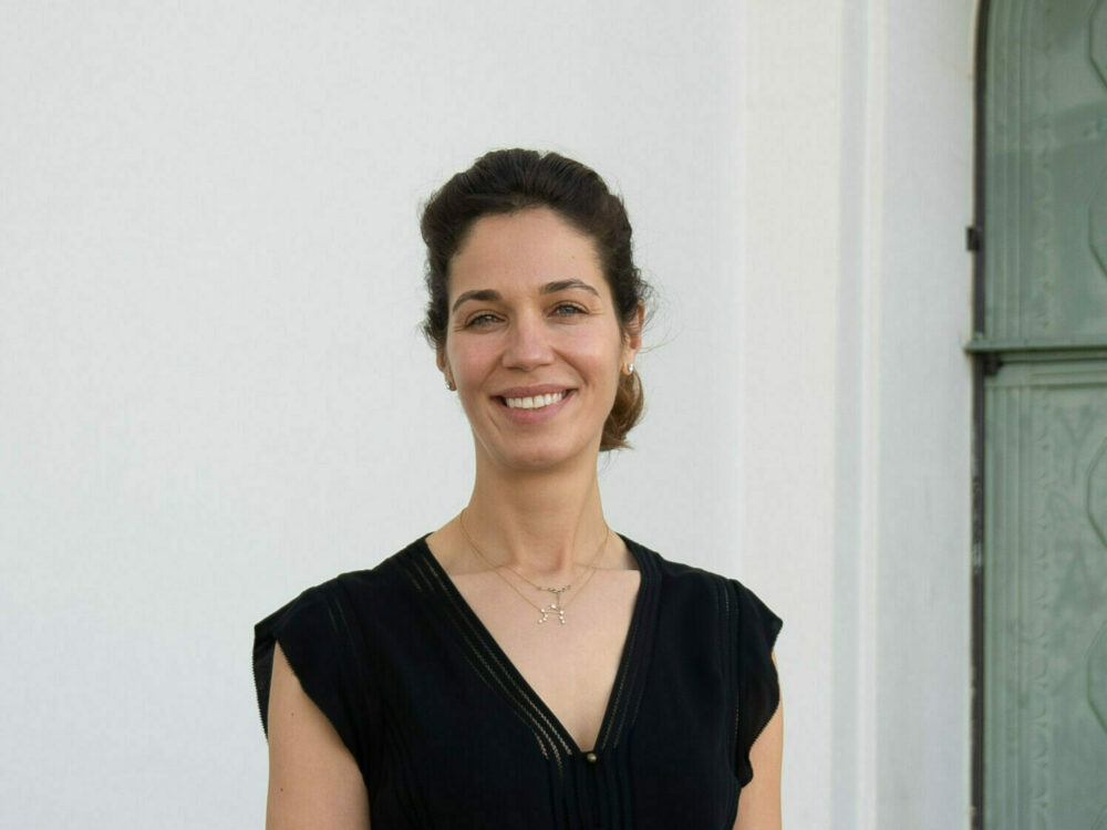 Shana Barghouti smiling at the camera next to the east exit of the Samuel Oschin Planetarium.